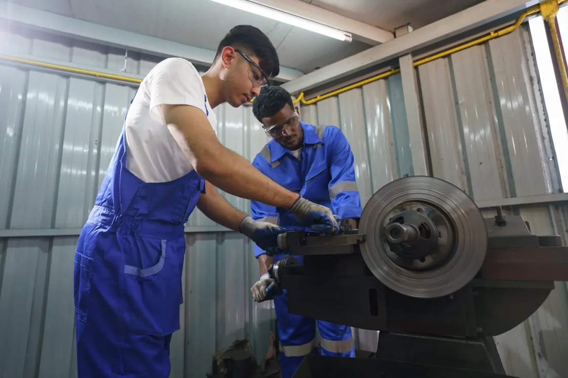 Two technicians are inspecting a brake lathe before use.
