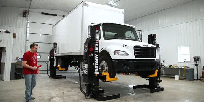 Mobile Rotary Lift suspending a large white box truck
