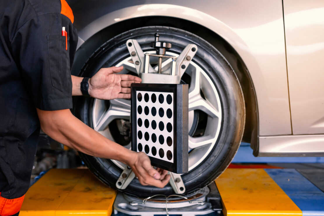 A technician positions a sensor for a wheel alignment